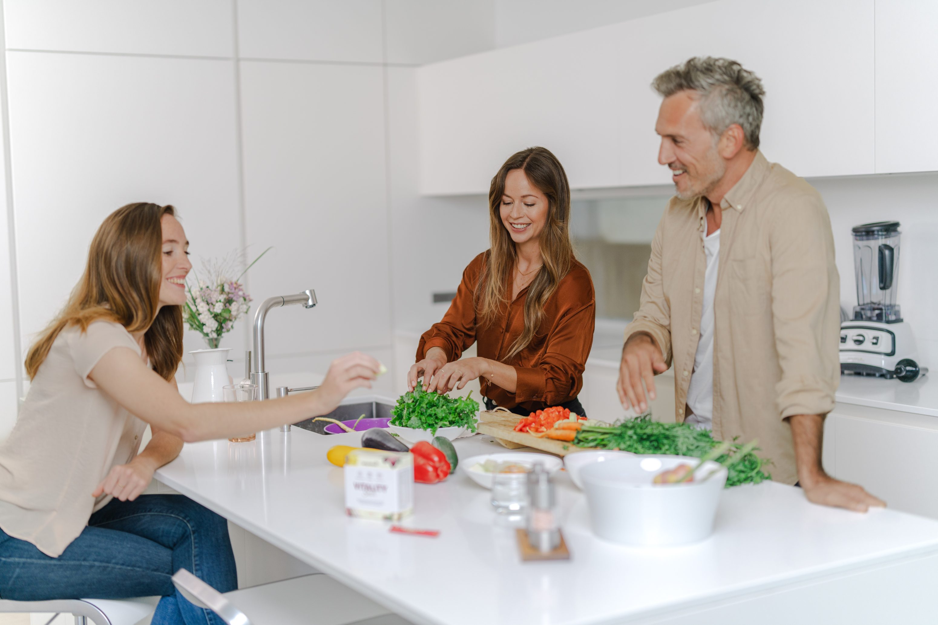 3 Personen kochen in einer hellen Küche