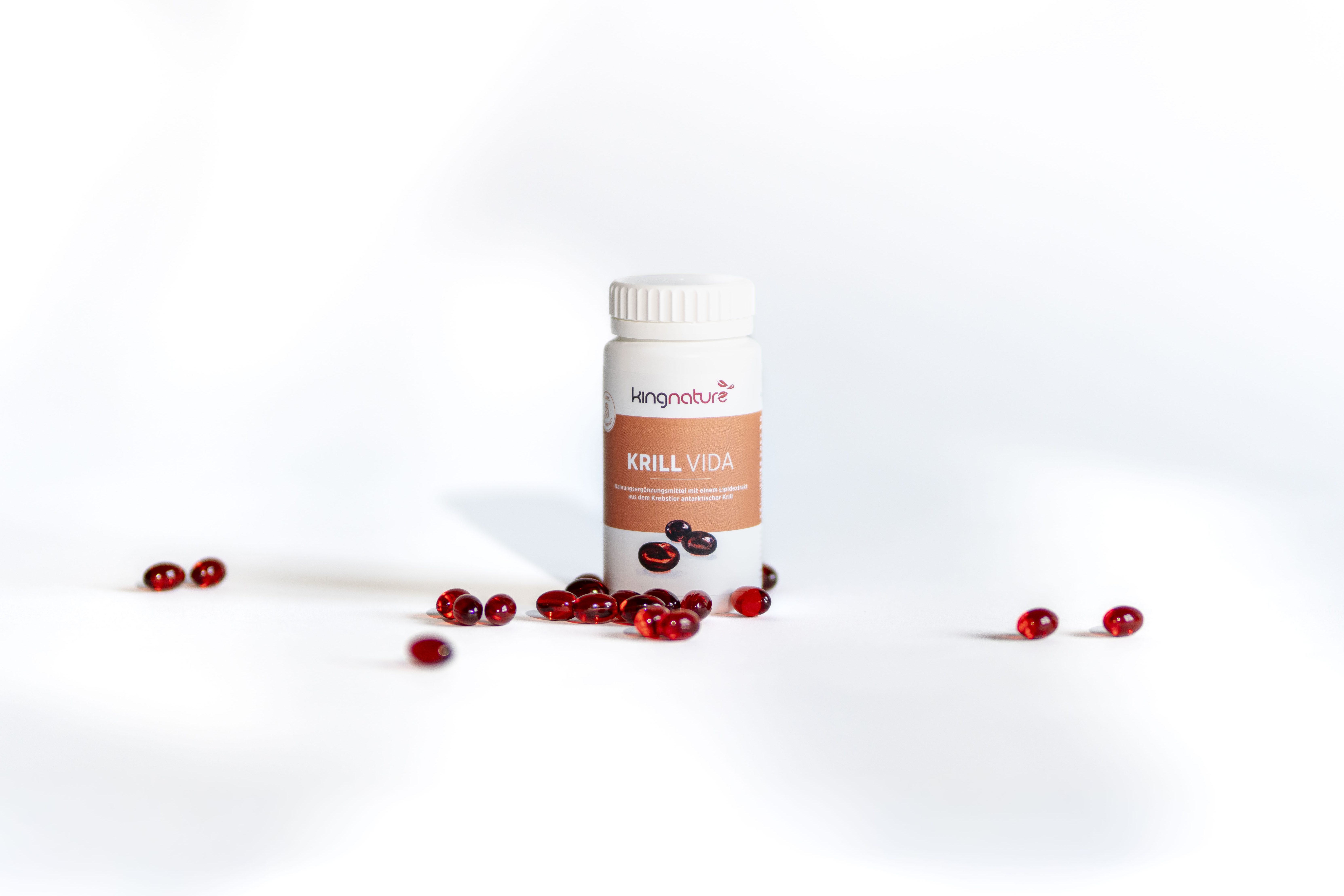 Eine weiße Flasche mit der Aufschrift KRILL VIDA mit roten Kapseln auf weißem Hintergrund. Auf dem Etikett steht außerdem der Markenname kingnature.