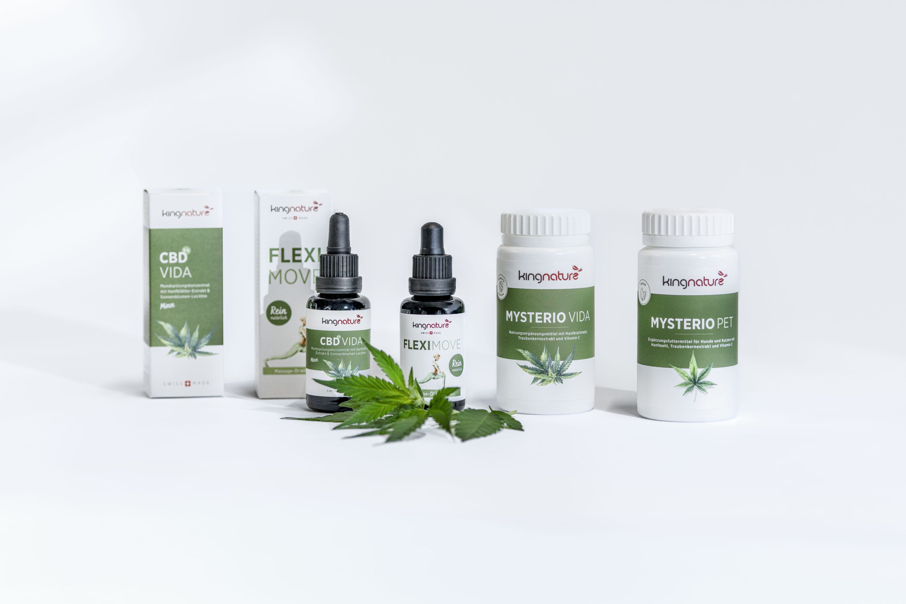 Eine Auswahl von KannaNature-Gesundheitsprodukten, darunter CBD Vida, Flexi Move, Mysterio Vida und Mysterio Pet, wird mit Tropfflaschen, Pillenflaschen, Schachteln und einem grünen Cannabisblatt präsentiert.