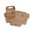 Eine kleine braune Geschenkbox aus Karton mit Henkel und aufgedrucktem Pflanzenmotiv steht aufgebaut vor mehreren flachen, unmontierten Kraftkartons.