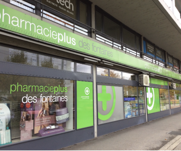 Eine moderne Apothekenfassade mit grüner Beschilderung mit der Aufschrift pharmacieplus des fontaines, großen Schaufenstern, in denen Produkte ausgestellt werden, und einem Gehweg davor - ein automatisch gespeicherter Entwurf des zeitgenössischen Designs im Gesundheitswesen.