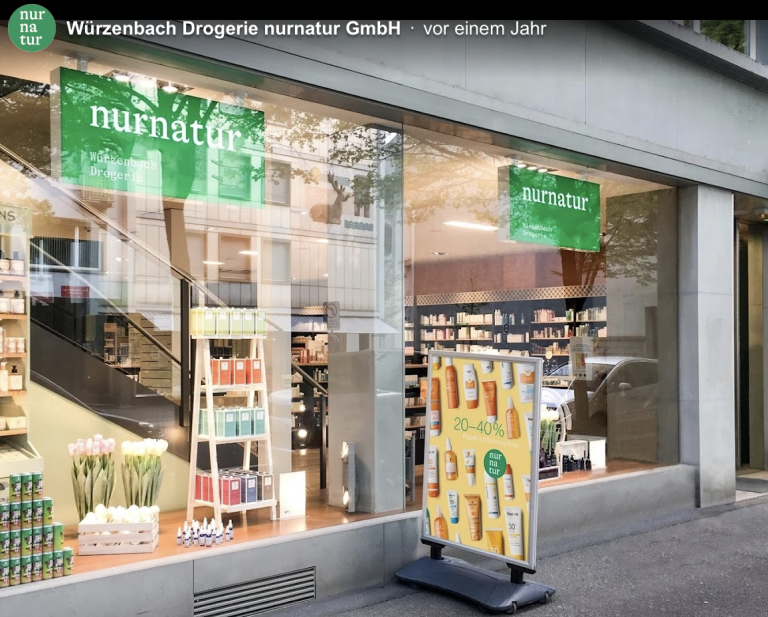 Straßenansicht eines Geschäfts mit großen Schaufenstern mit Nurnatur-Schildern, Regalen mit Gesundheits- und Schönheitsprodukten, Tulpen und einem Stand auf dem Bürgersteig - ein automatisch gespeicherter Entwurf wirbt für 20-40 % Rabatt auf Hautpflegeprodukte.