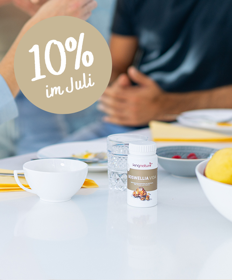 Offene Tablettenfläschchen mit roten Kapseln und Muscheln liegen verstreut auf einer Oberfläche. Ein rundes Etikett mit der Aufschrift „10 % im Mai“ weist auf einen 10%igen Rabatt auf Kingnature Nahrungsergänzungsmittel aus der Schweiz hin. Das Bild wirkt in einem sanften, werbenden Stil.