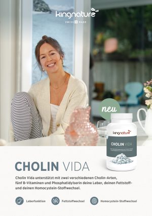 Eine lächelnde Frau sitzt an einem Tisch mit einer Tasse, neben der ein großer Behälter mit dem Nahrungsergänzungsmittel Produkte-Flyer (ohne Muster) steht. Text und Flyer heben die Vorteile für die Leberfunktion, den Fettstoffwechsel und den Homocystein-Stoffwechsel hervor.