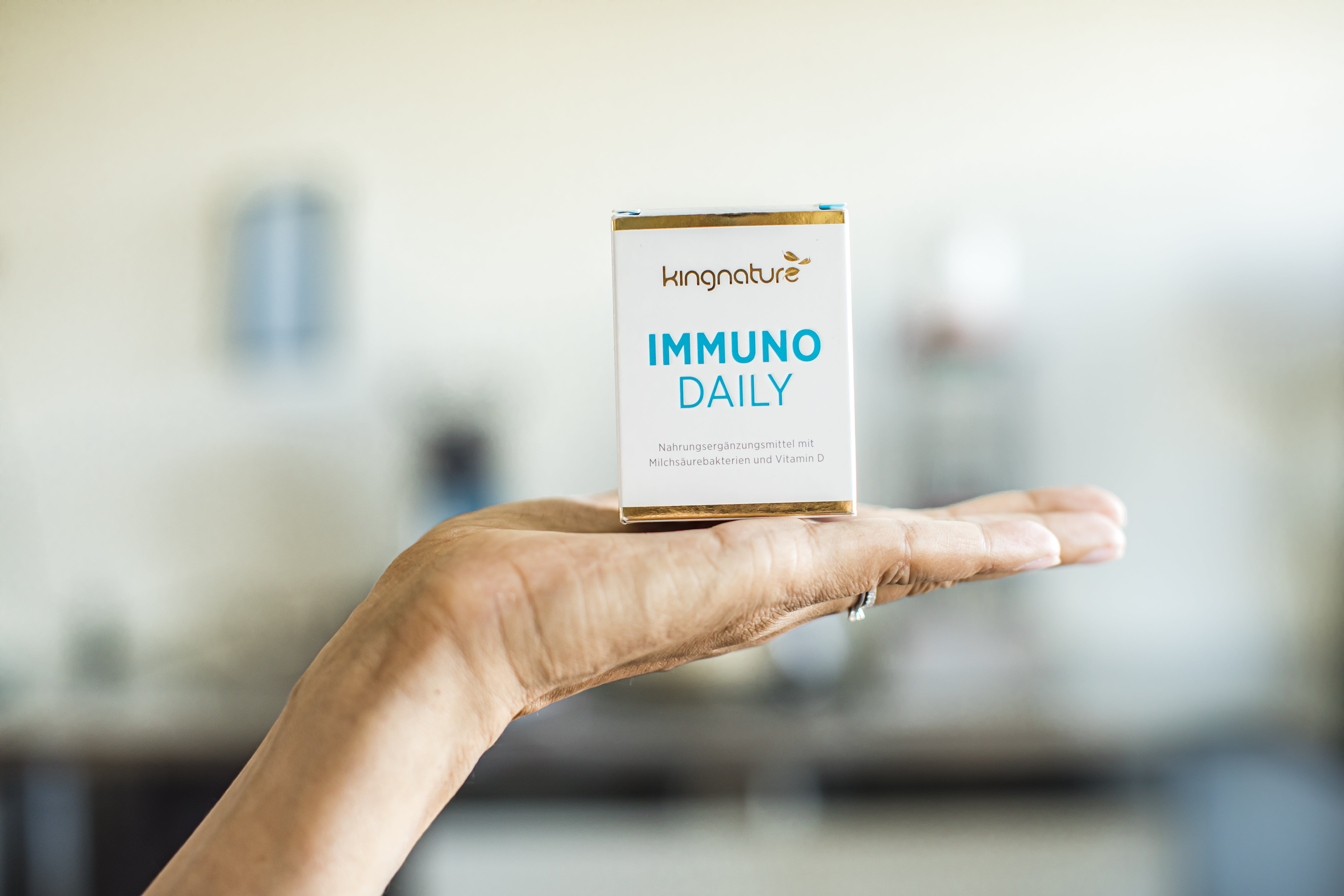 Immuno Daily, Immuno, kingnature, Nahrungsergänzungsmittel, Milchsäurebakterien, Vitamin D, Immunsystem, 60 Kapseln, Immunsystem stärken, Colostrum, 100% natürlich, Swiss made, Gentechfrei, 7 verschiedene Stämme, Milchsäure-Bakterienkulturen, Bakterien, 100 Millionen Bakterien, Kapsel, Lacto-Vegetarier, Vegetarier, Lactose, vermentierte Milch, Vegi-Kapselhüllen, Schweizer Produkt, hochwertige Rohstoffe, schonend verarbeitet, Top Qualität, Hand, Ring, Verpackung, blau, weiss, Nahrungsergänzungsmittel