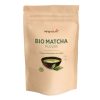 In einem beigen, wiederverschließbaren Beutel mit der Aufschrift Matcha Pulver Bio befindet sich eine Schale mit grünem Matcha-Pulver mit Blättern, die den Bio-Matcha aus Japan hervorheben - perfekt für alle, die Matcha Pulver kaufen möchten.