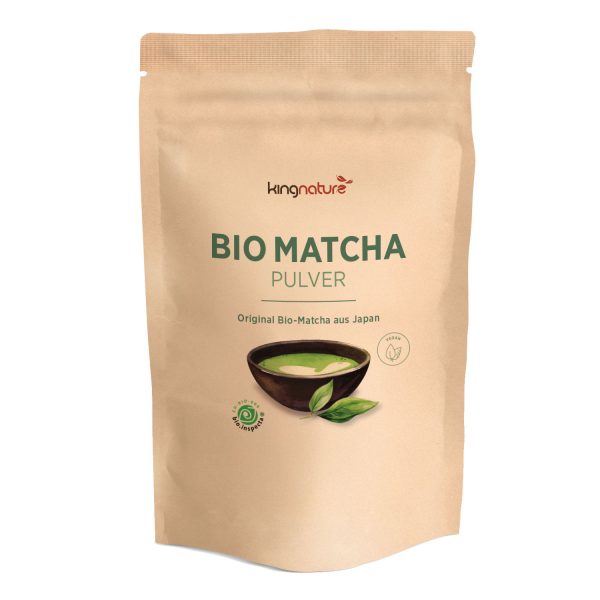 In einem beigen, wiederverschließbaren Beutel mit der Aufschrift Matcha Pulver Bio befindet sich eine Schale mit grünem Matcha-Pulver mit Blättern, die den Bio-Matcha aus Japan hervorheben - perfekt für alle, die Matcha Pulver kaufen möchten.