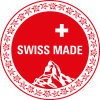 Ein rotes, rundes Schild mit der Aufschrift „SWISS MADE“ in Weiß, darüber ein weißes Kreuz, darunter eine Bergillustration und ein Rand mit einer Edelweißblüte – ideal für alle, die Aronia Schokolade kaufen möchten.