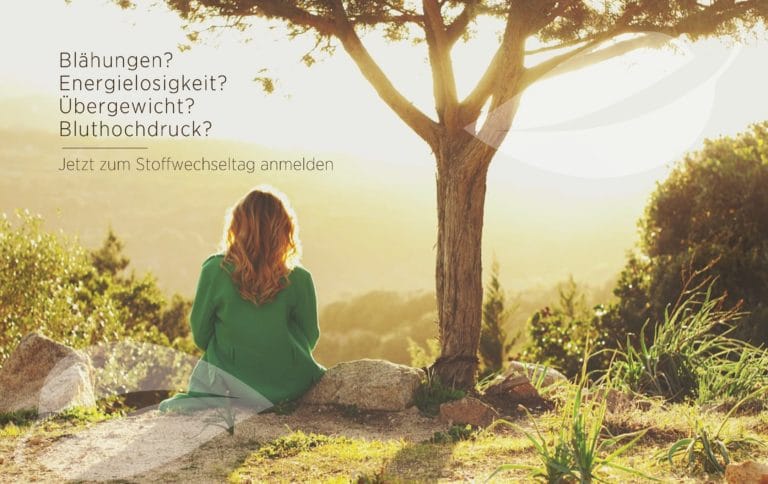 Eine Frau mit langen Haaren sitzt im Freien auf einem Felsen und blickt auf ein malerisches Tal mit Bäumen im Sonnenuntergang. Der deutsche Text links fragt nach Blähungen, Energiemangel und Bluthochdruck und lädt Sie ein, sich für einen Stoffwechseltag anzumelden, um Ihre Vitalität zu steigern.