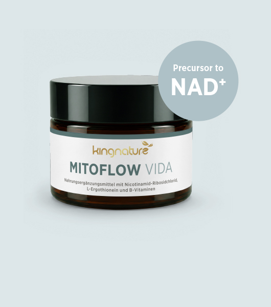 Eine weiße Flasche mit der Aufschrift Boswellia Vida von kingnature steht auf einem weiß gedeckten Tisch mit Geschirr, Obst und Gläsern. In einem beigen Kreis steht "10% im Juli". Zwei Personen sitzen am Tisch, nur ihre Arme und Oberkörper sind zu sehen.